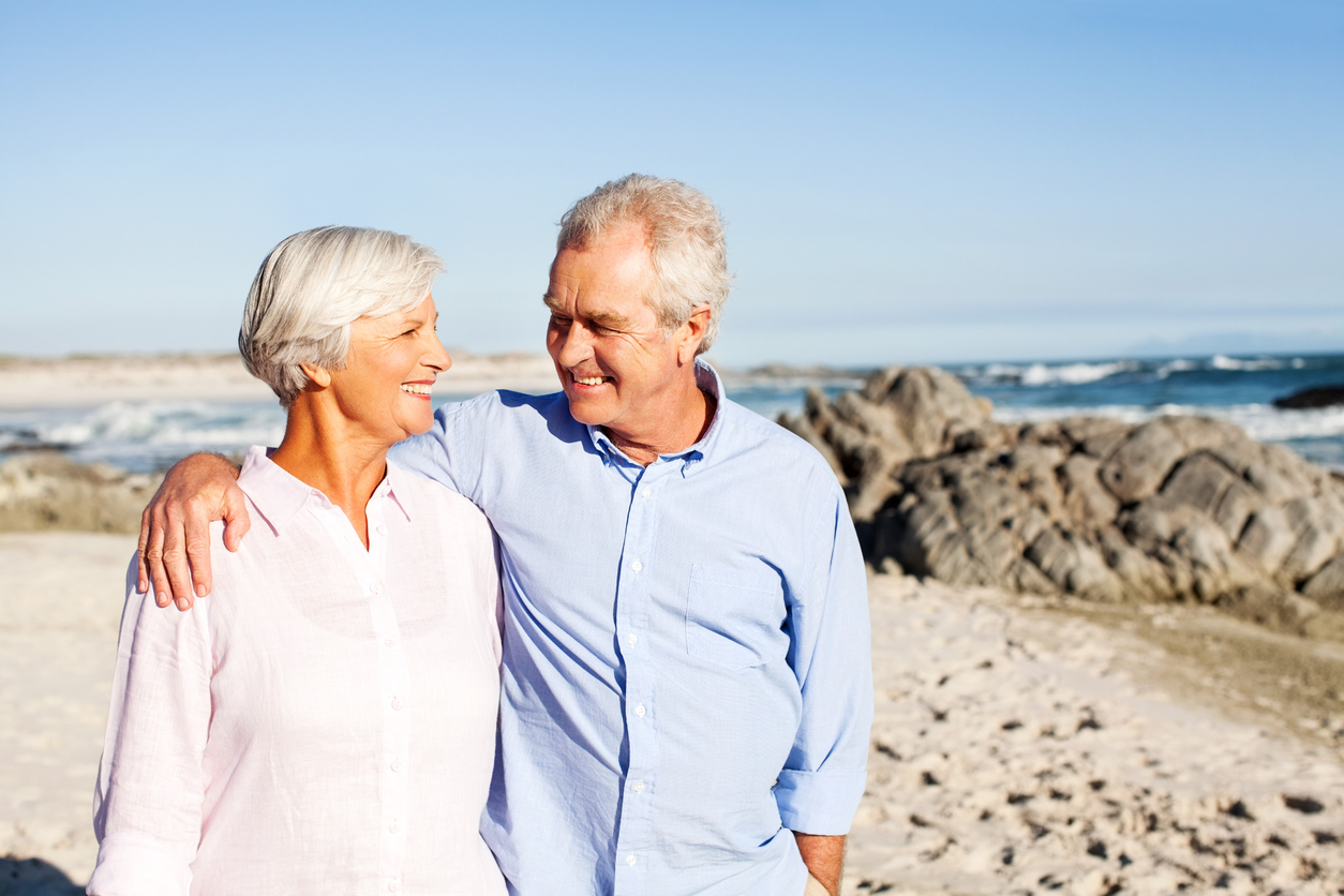 senior couple walking on beach